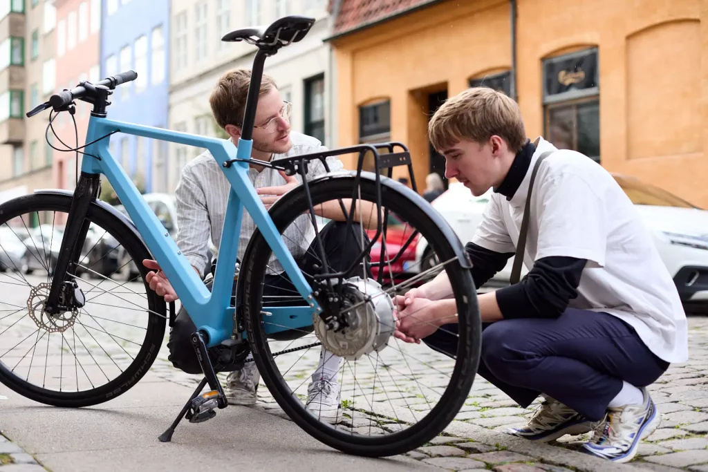 Young man showing friend his sky blue Erik Urban with Zehus motor system in Copenhagen